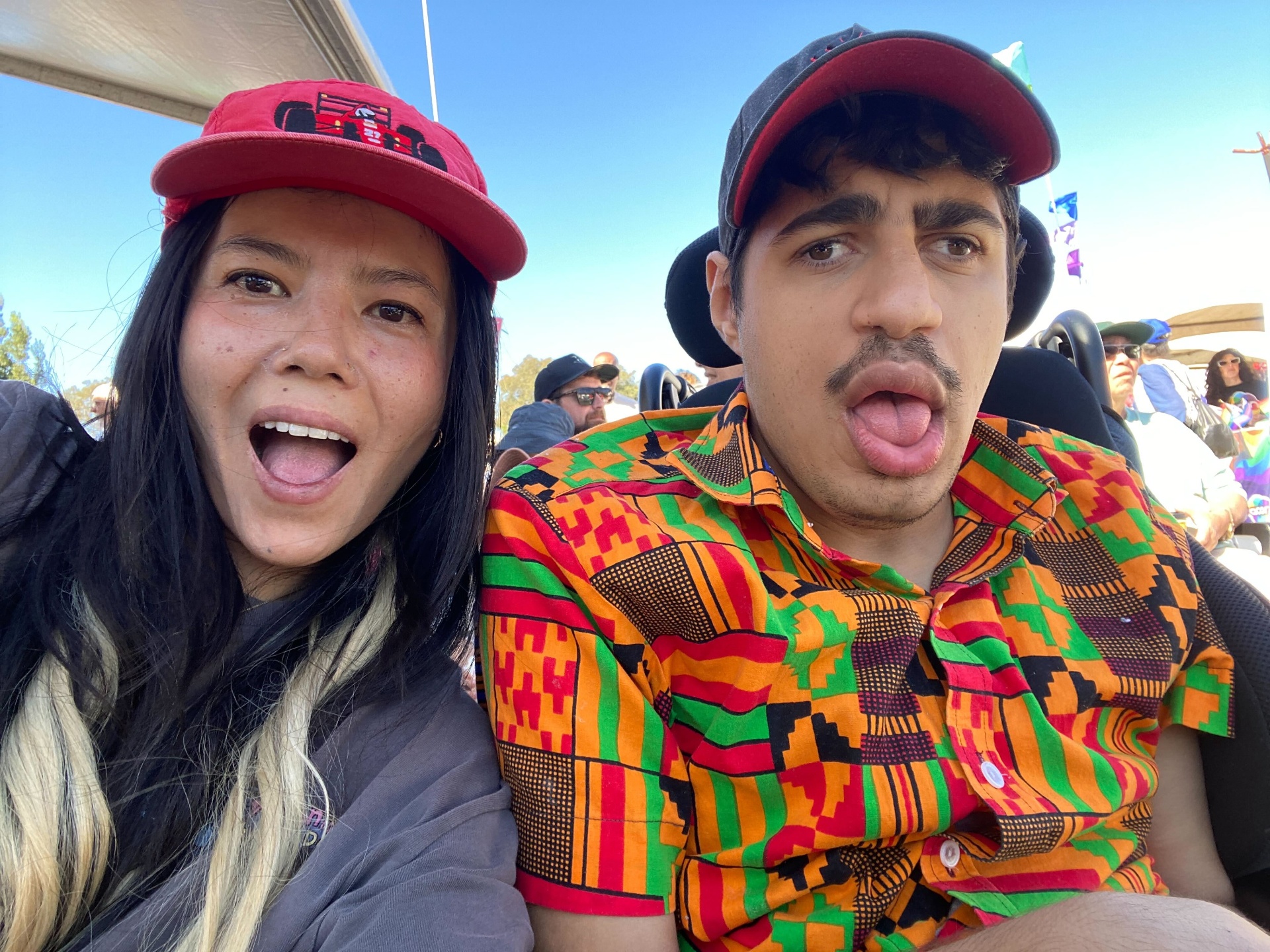 A participant and their support worker laughing together at a community event