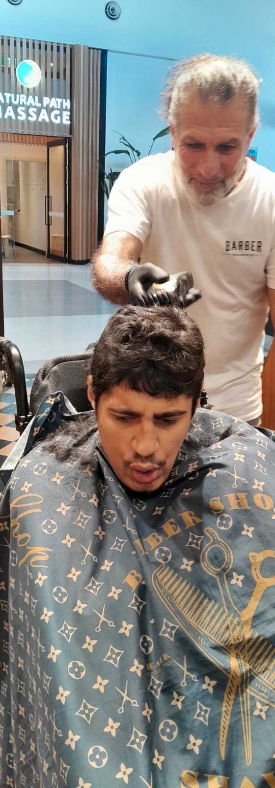 A Good Shepherd participant getting a fresh haircut from a community barber